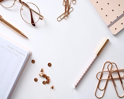 A well-organized modern workspace table with a notepad and stationary items ready for messaging